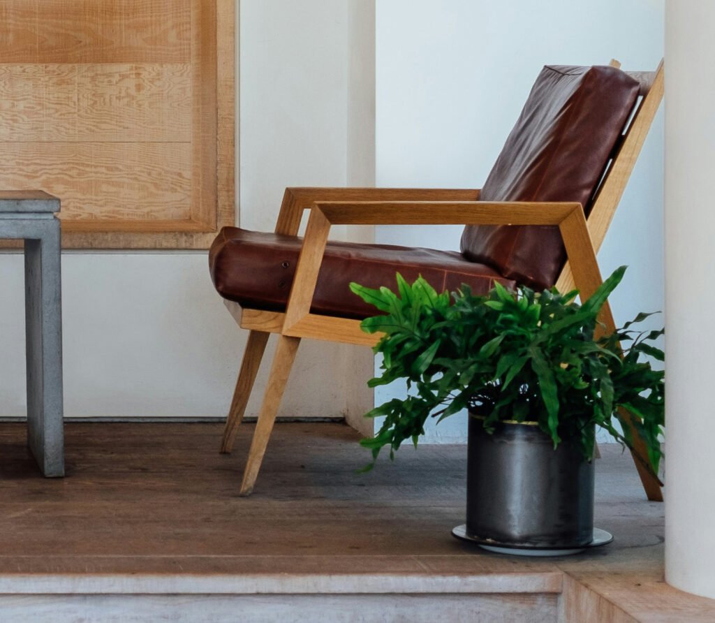 Mid-century modern accent leather chairs with solid wooden frames and thick brown leather cushions, stylish lounge seating for contemporary interiors.